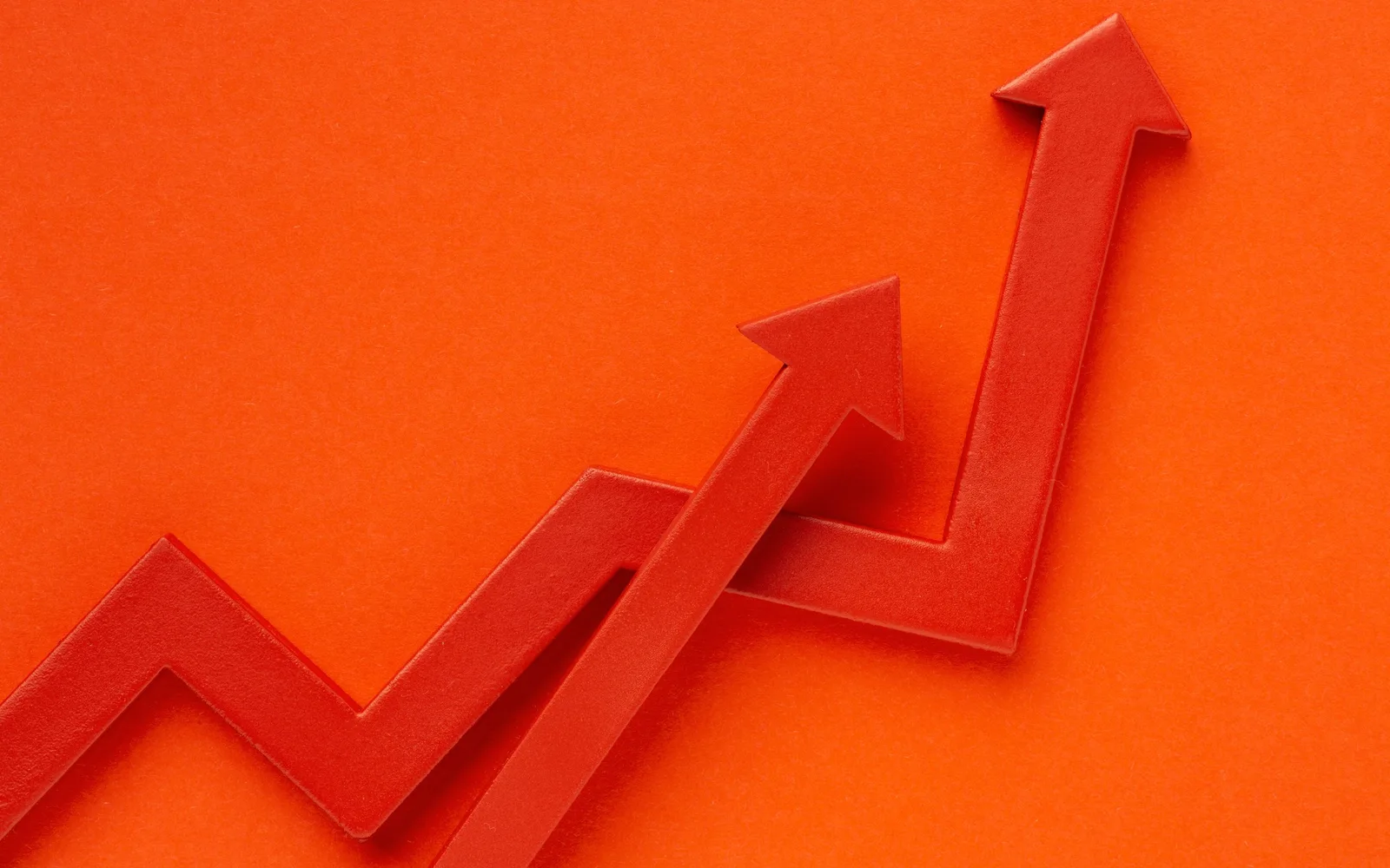 Layered orange arrows rising upward to represent responsible growth across markets